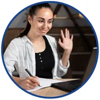 Szkolenia online z MS Excel i obsługi klienta – kobieta macha do kamery laptopa podczas rozmowy wideo i notuje