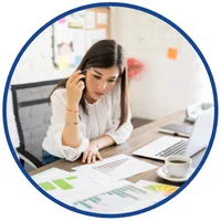 Kurs online z analizy finansowej i Excela – kobieta przegląda wydruki z wykresami przy laptopie