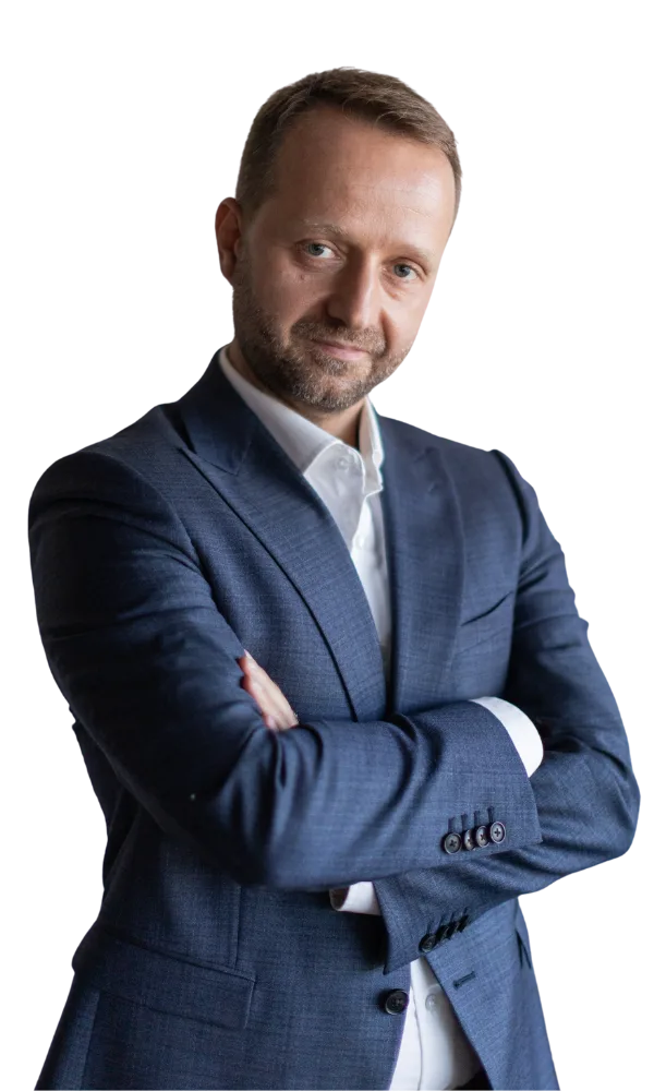 Jarosław Włoch – trener kursu VAT, w granatowym garniturze, z założonymi rękami