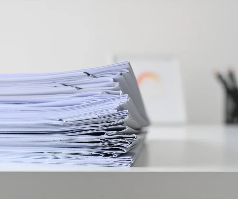 Kompendium kadrowe dla JSFP 2026 – stos dokumentów spiętych klipsami na białym biurku