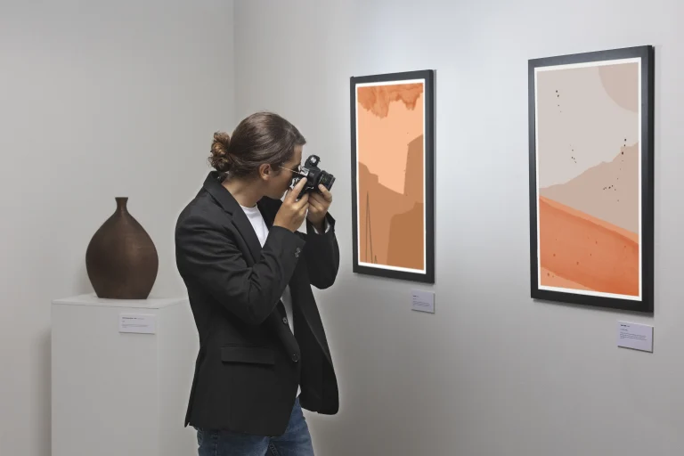 Kompendium kadrowo-płacowe kultury 2026 – osoba fotografuje abstrakcyjny obraz w galerii sztuki